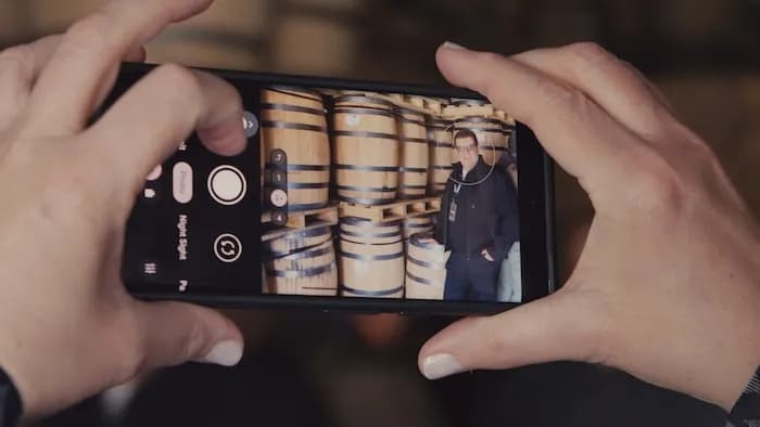 Someone photographing a stack of barrels on a phone