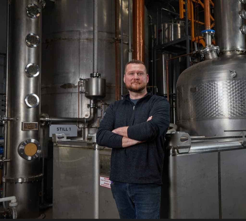 A distiller standing in front of the still house